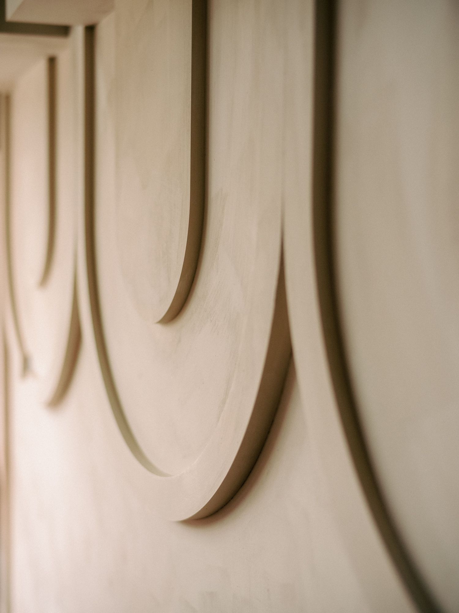 Modern wall paneling with elongated vertical grooves in a neutral beige color.