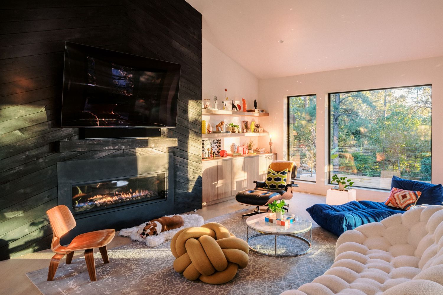 Modern living room interior with large windows and comfortable seating area bathed in natural light.