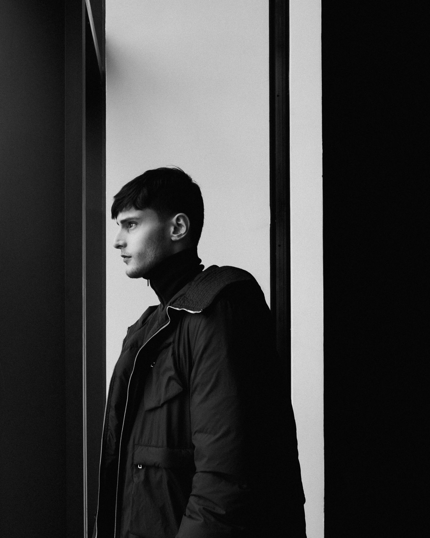 Artistic black and white portrait series showing dramatic side profile lighting.