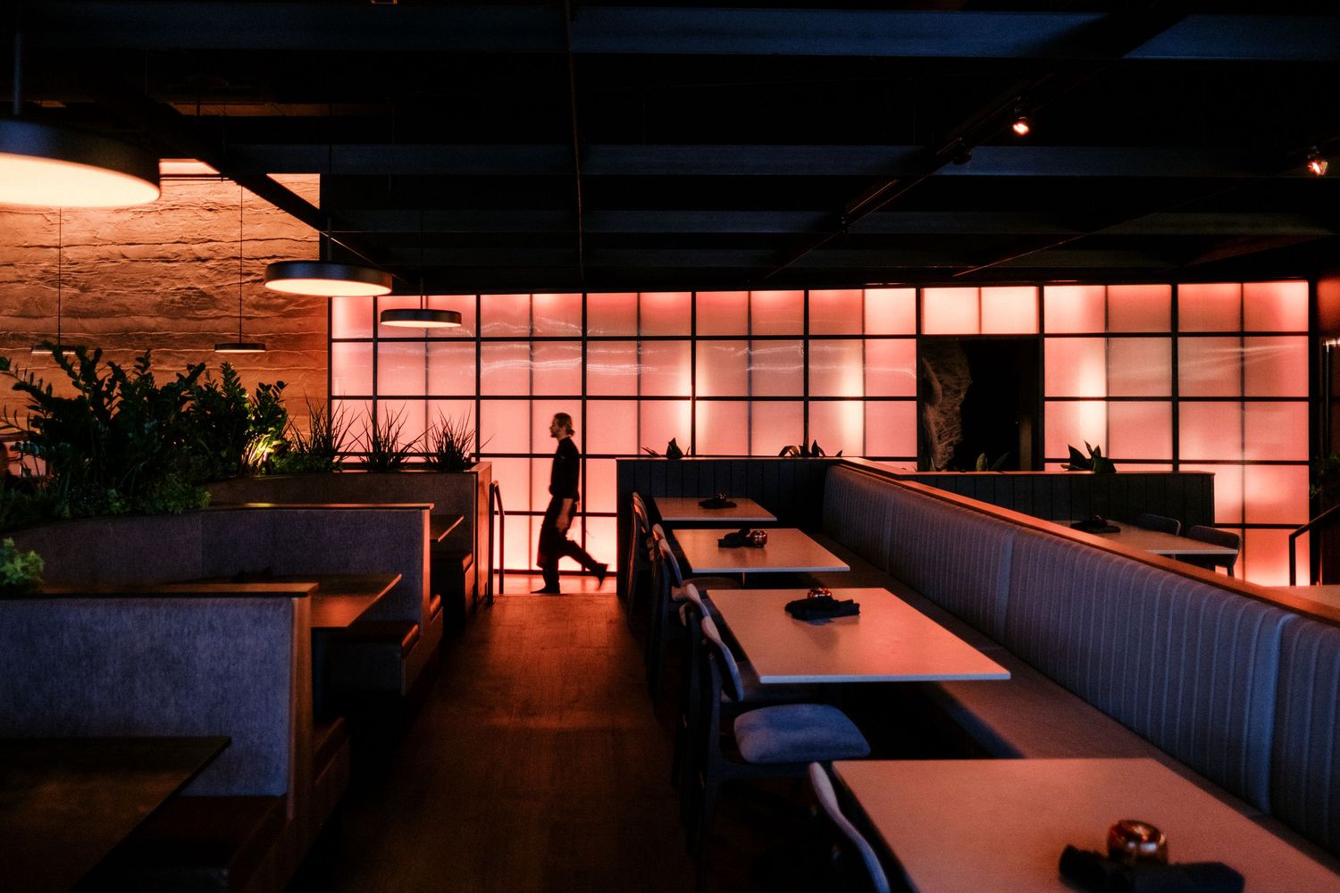 Sunset casts warm orange glow through large windows in modern industrial space.