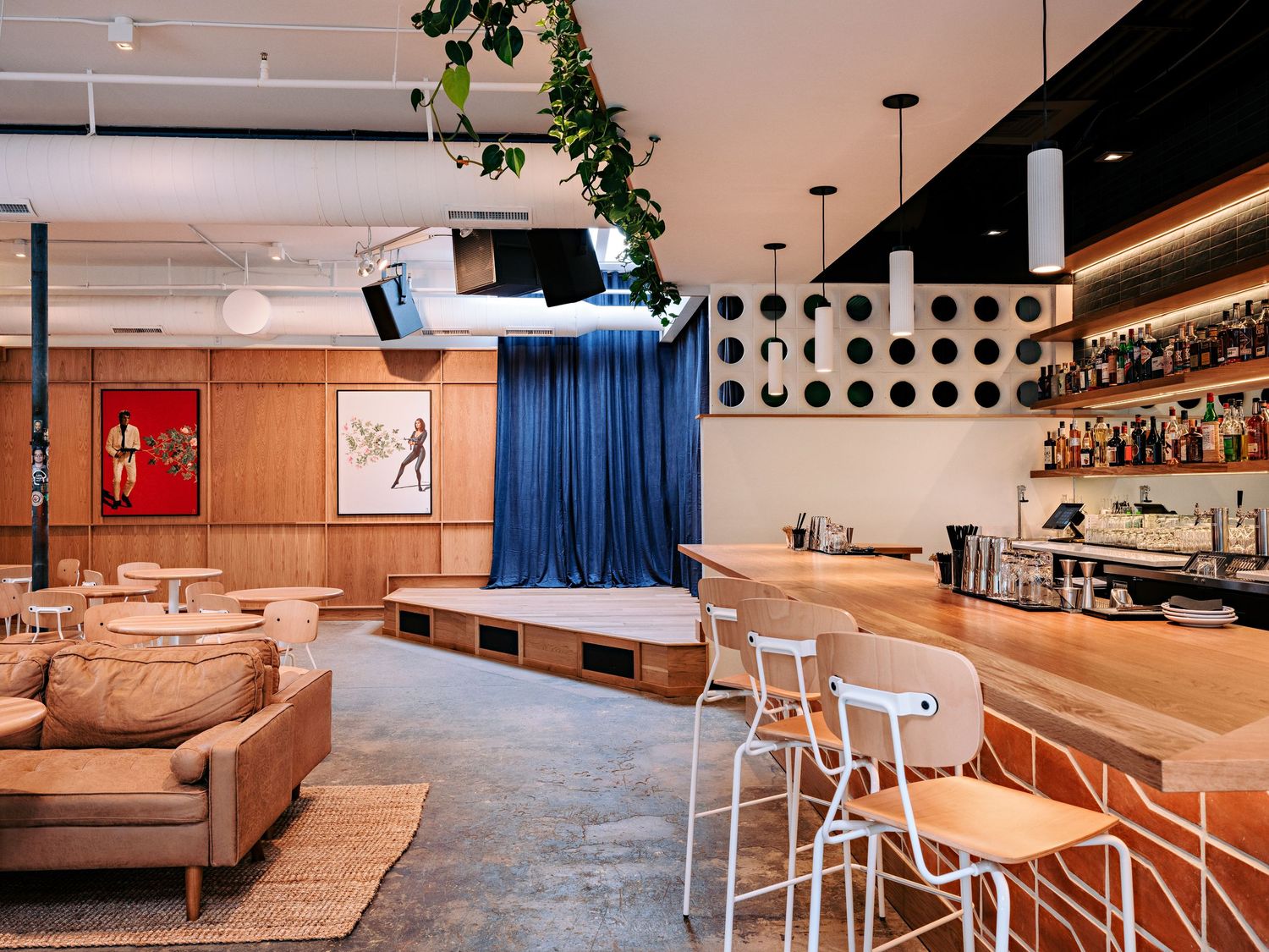 Contemporary restaurant layout with curved seating areas, concrete floors, and modern lighting fixtures.