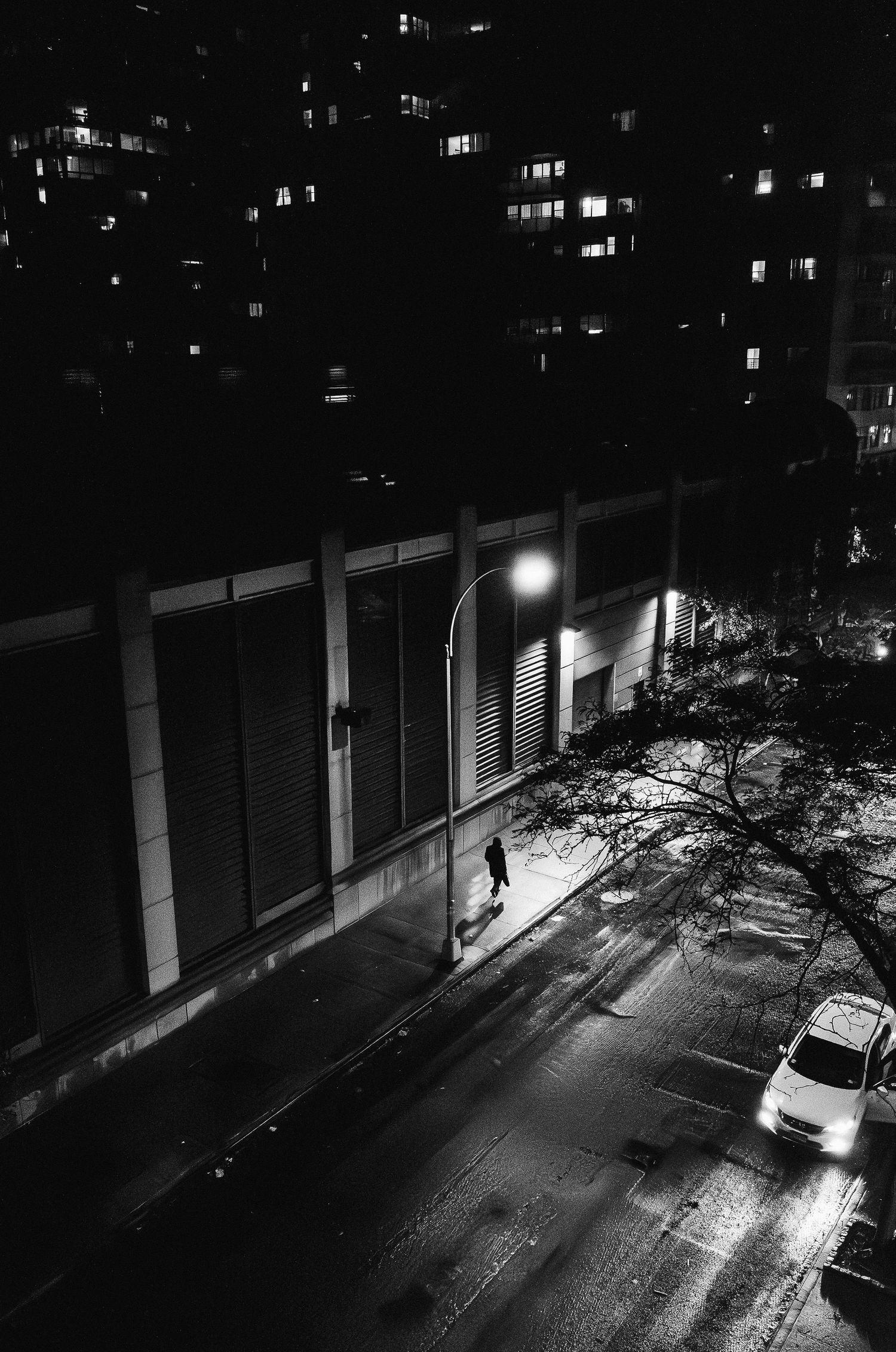 A sequence of surveillance camera footage shows a person walking alone on a dark street at night.