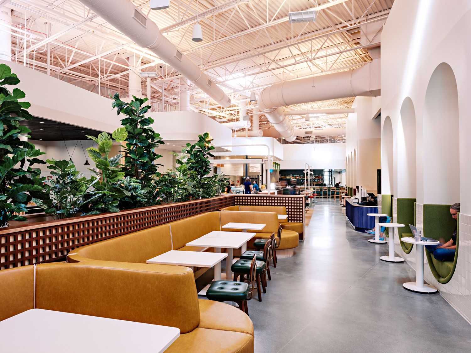 Contemporary dining area with tan booth seating and abundant natural lighting.