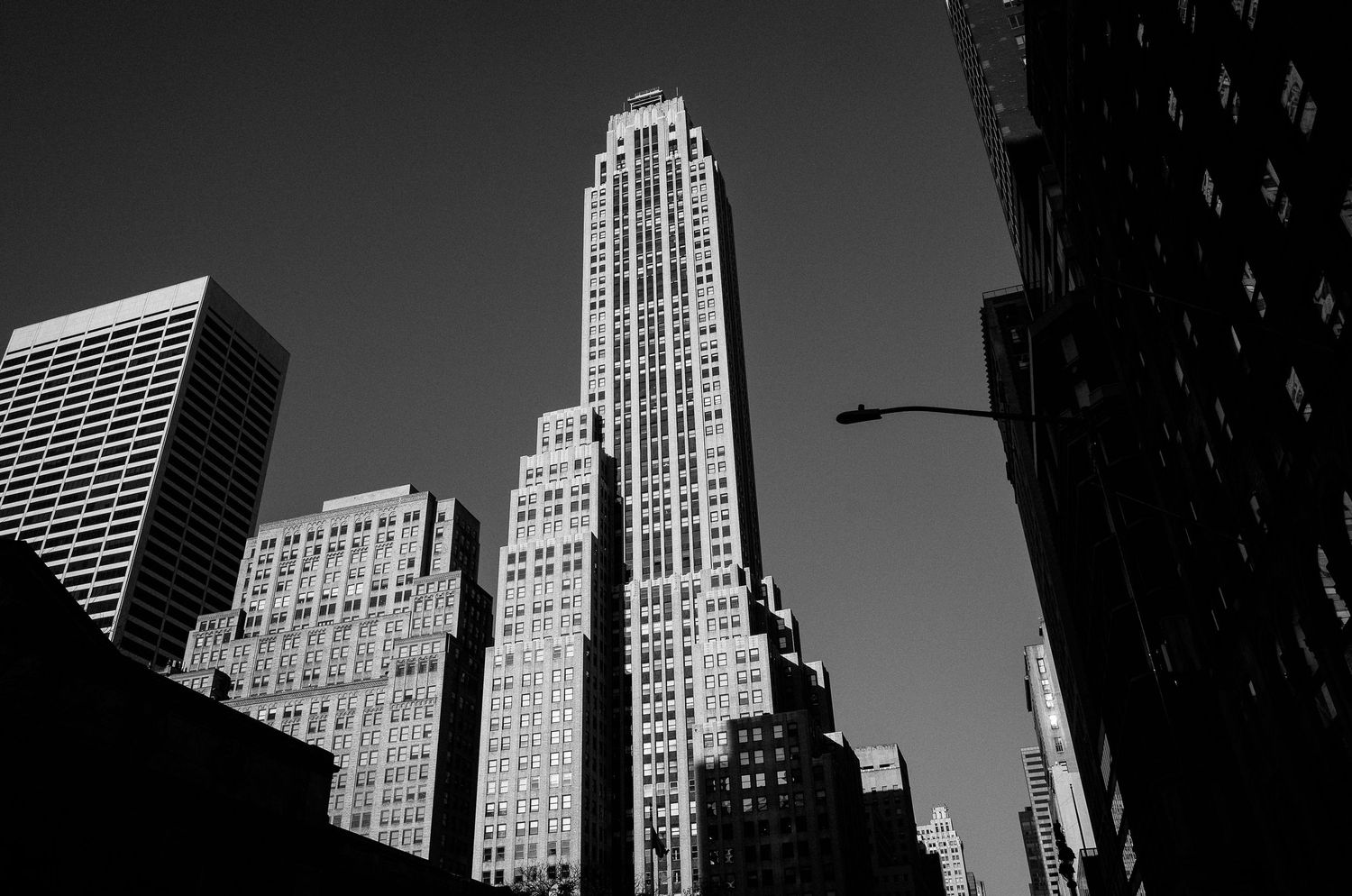 Black and white architectural photograph of art deco skyscrapers in New York City against a dark sky.