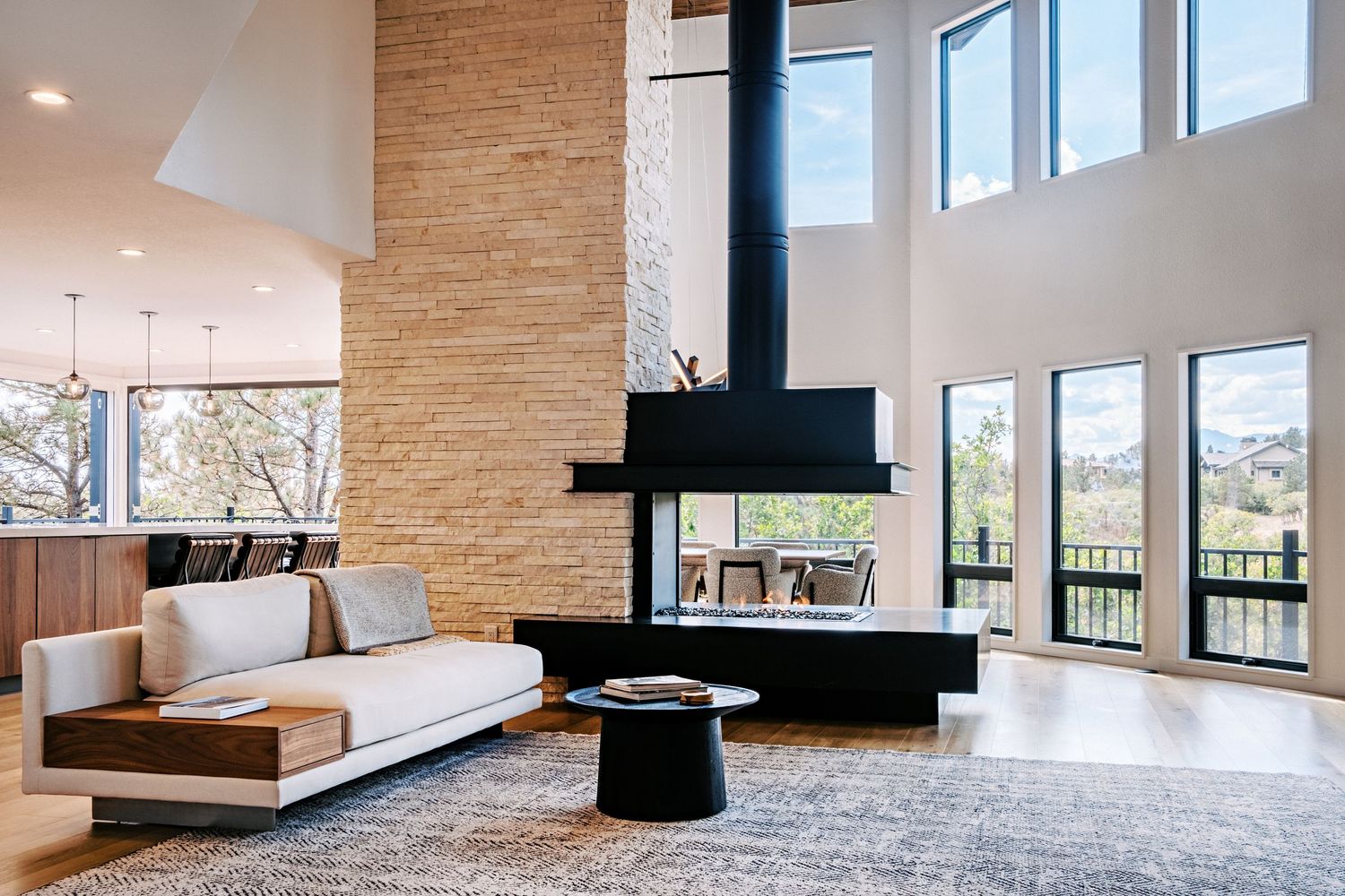 Bright interior space featuring stone walls, high ceilings, and large windows with mountain views.