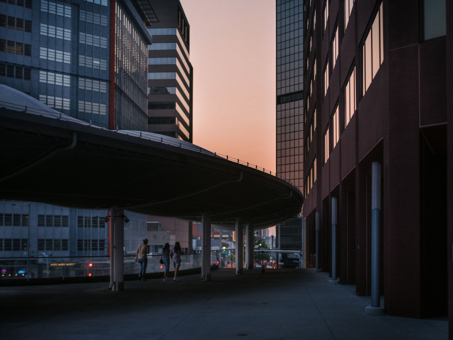 Modern office buildings with glass facades reflecting the warm sunset light in an urban setting.