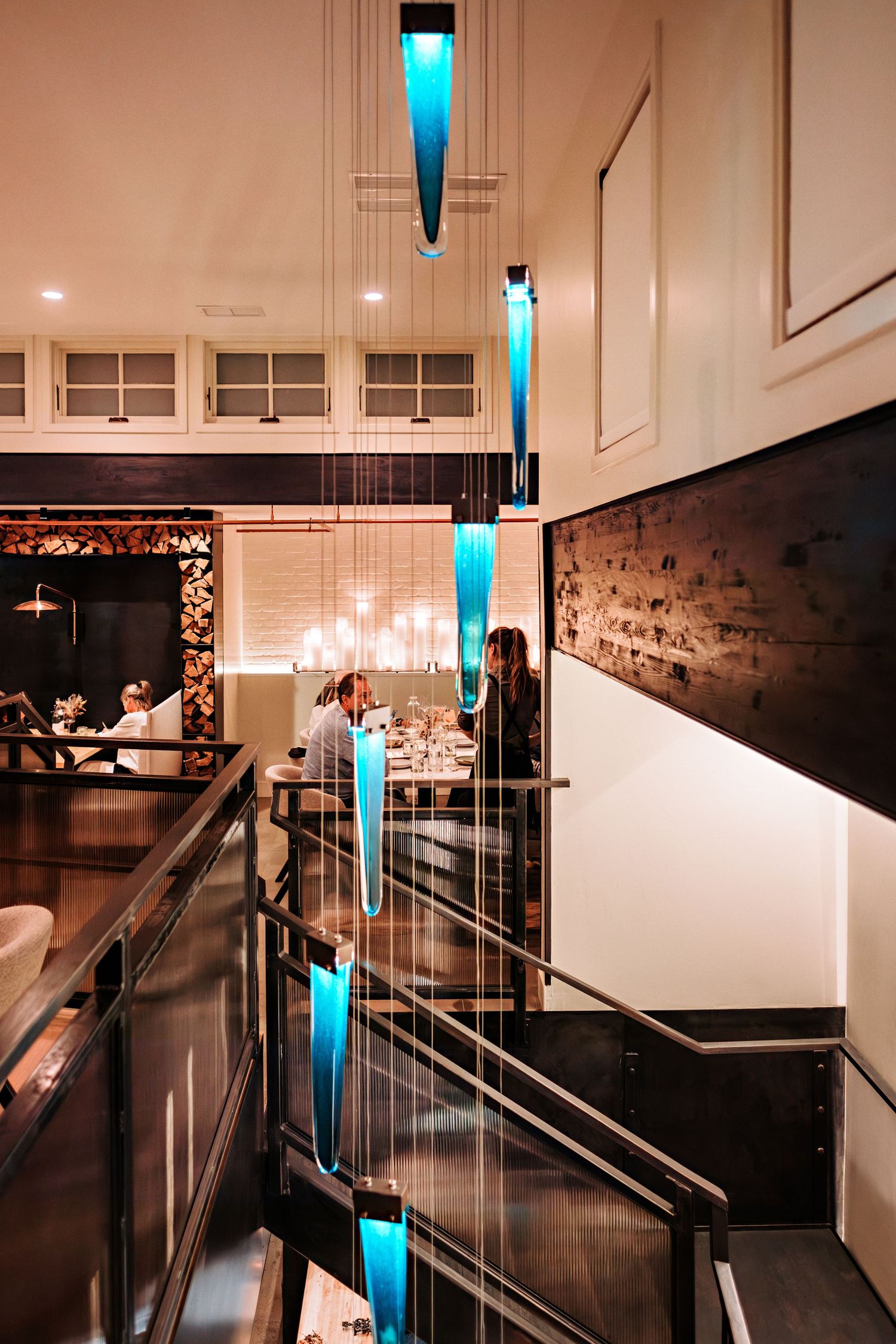 Modern hallway with blue accent lighting and glass railings in contemporary interior design.