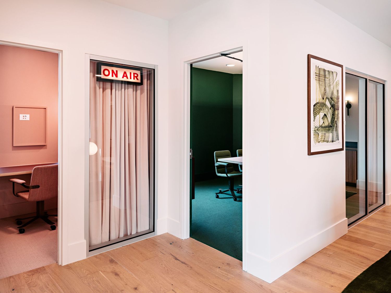 Long corridor with white walls and multiple doorways in modern office building.