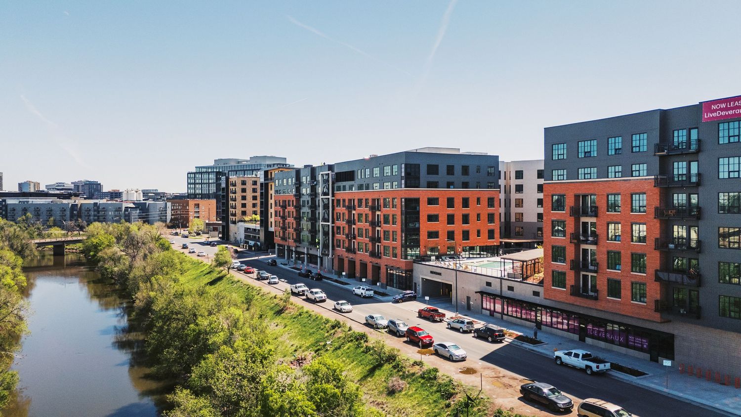 Panoramic view of modern residential development with parking lots and landscaping.