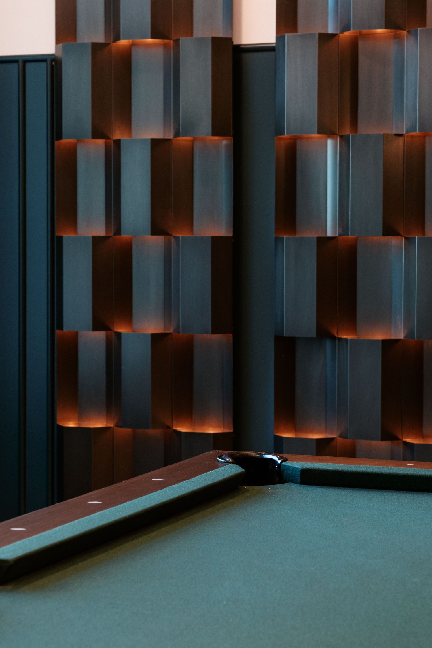Modern acoustic wall panels with dramatic lighting create geometric patterns.