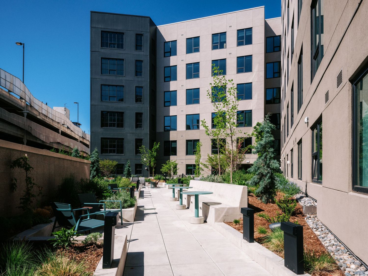 Exterior view of modern commercial building with landscaped walkways and seating areas.