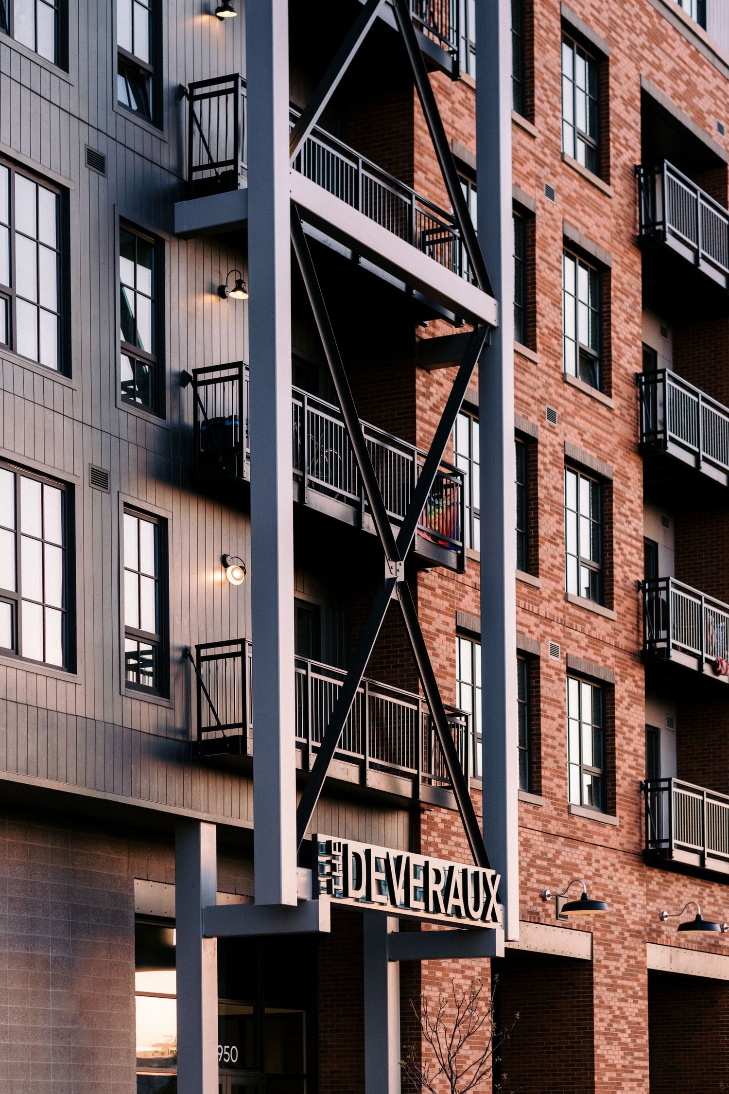 Contemporary apartment exterior featuring exposed brick, metal beams, and modern architectural elements.