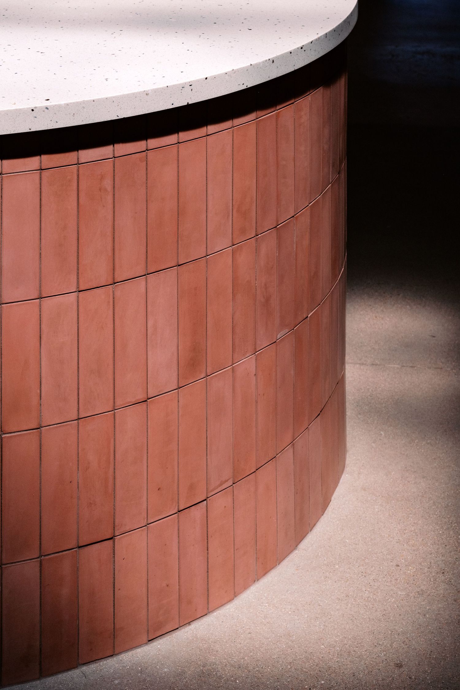 Curved architectural detail showing terracotta-colored wooden paneling with white top edge.