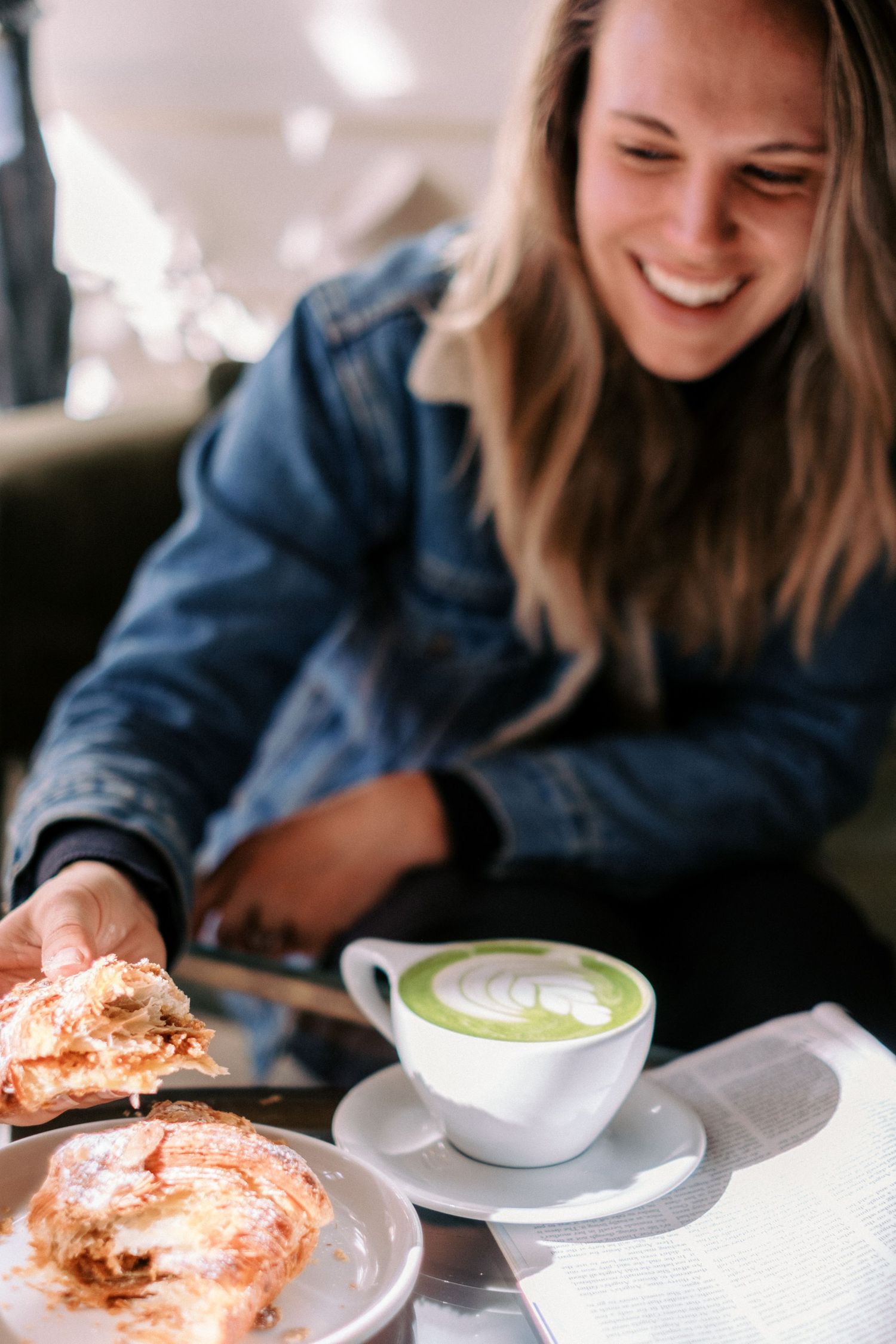 Cafe scene with coffee and pastries on white plates.