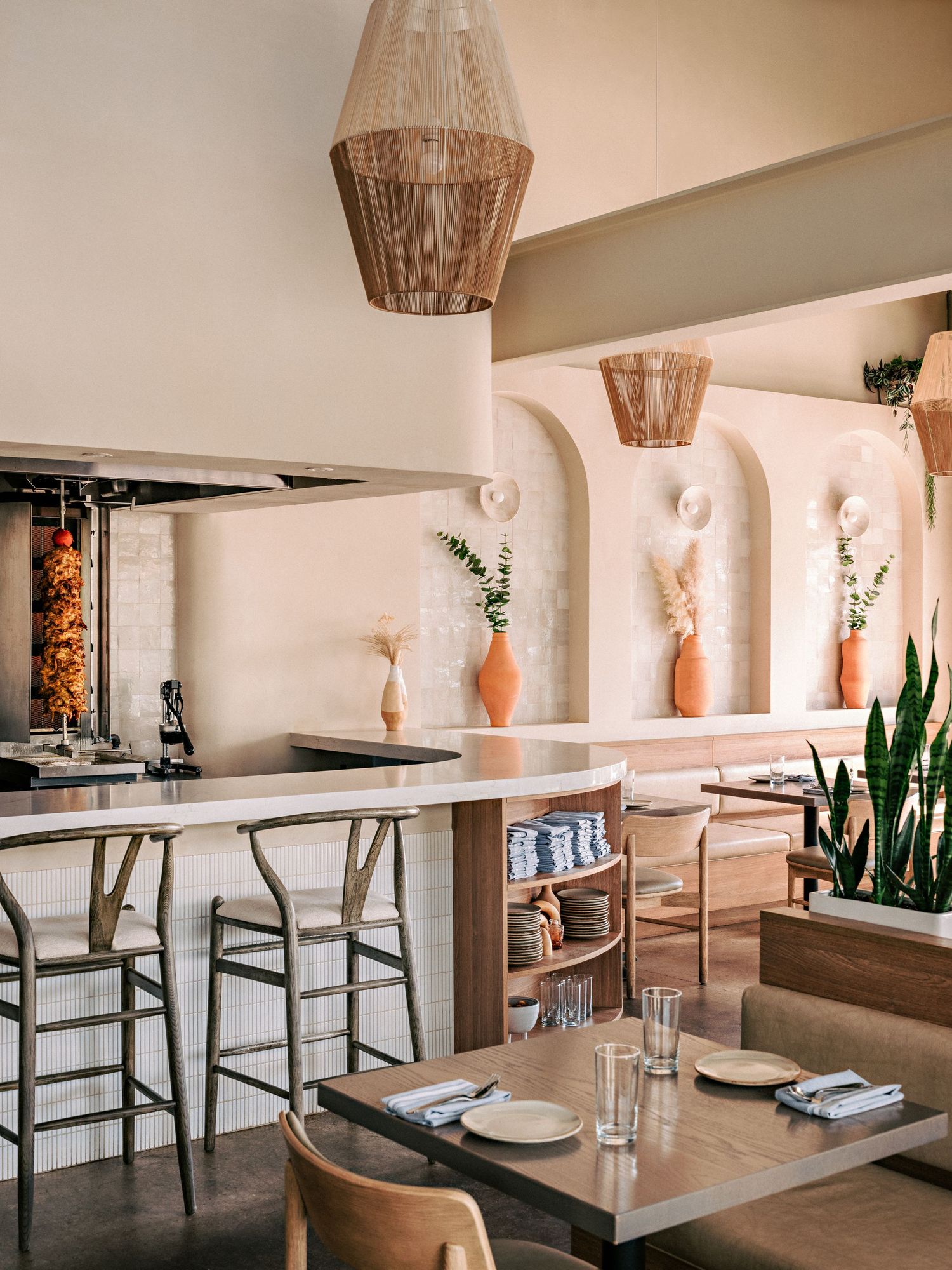 Sleek restaurant interior with modern furnishings, built-in alcoves, and botanical decorative elements.