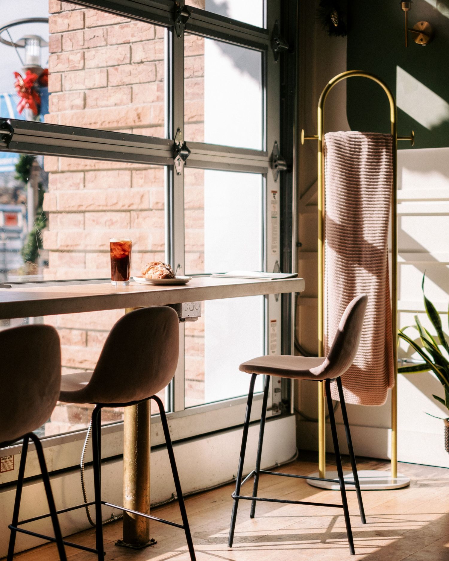 Modern cafe interior with brown leather chairs and exposed brick walls.