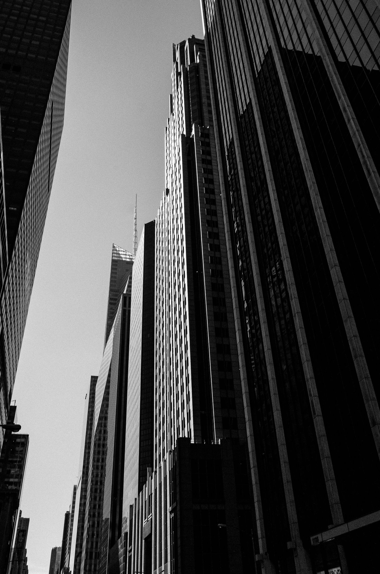 Dramatic black and white upward view of tall skyscrapers in a city creating stark geometric patterns against the sky.