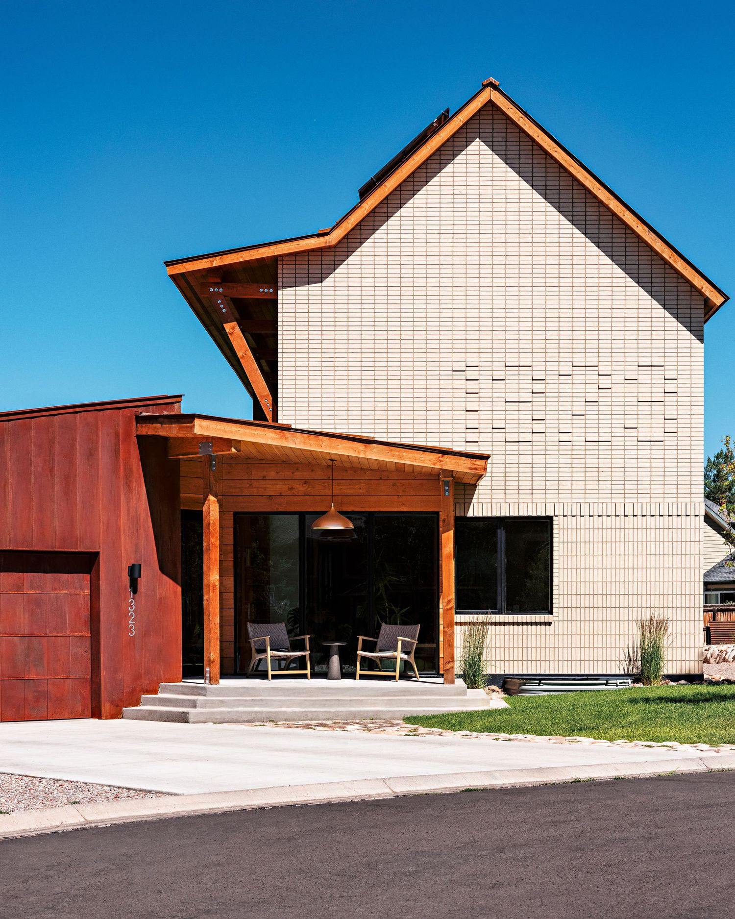 Modern building exterior with white walls and rustic wood accents under bright blue sky.