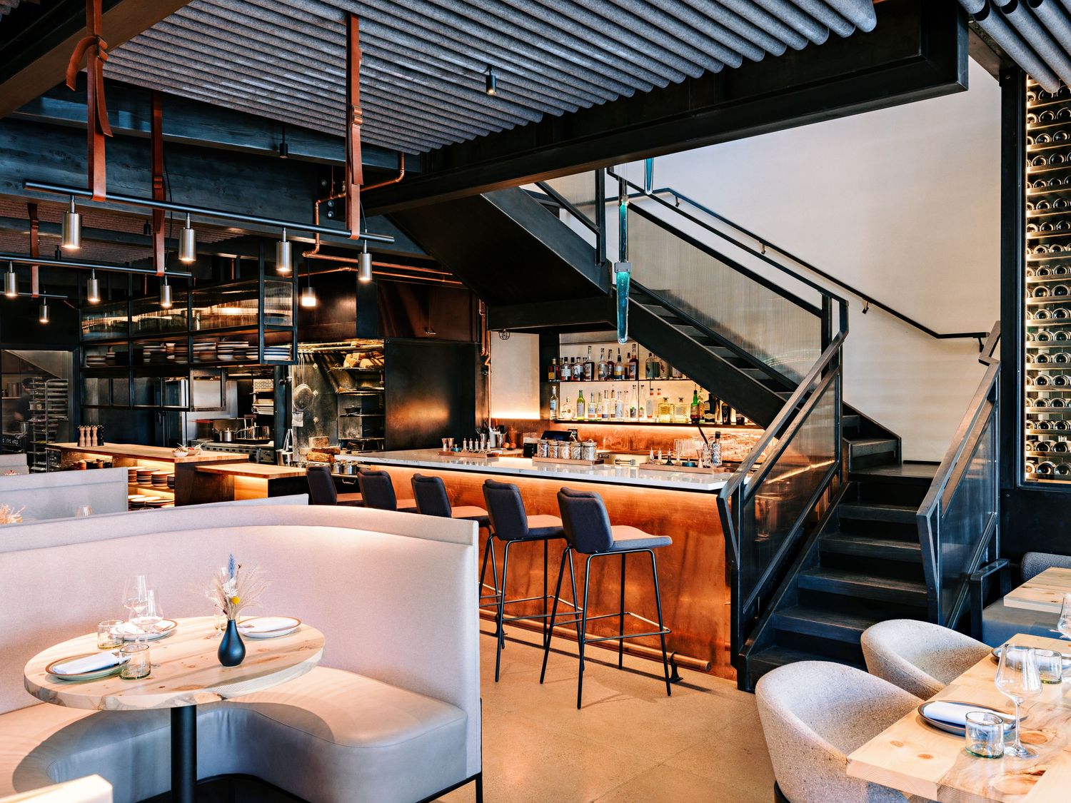 Upscale dining space with modern white seating and industrial-style ceiling design.