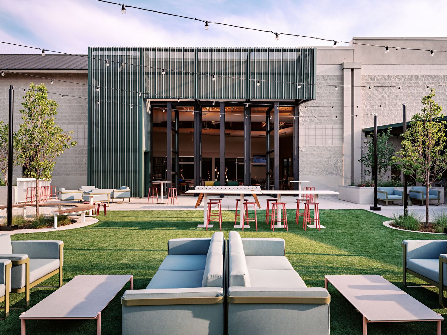 Outdoor seating area with modern concrete benches and landscaping against a commercial building.