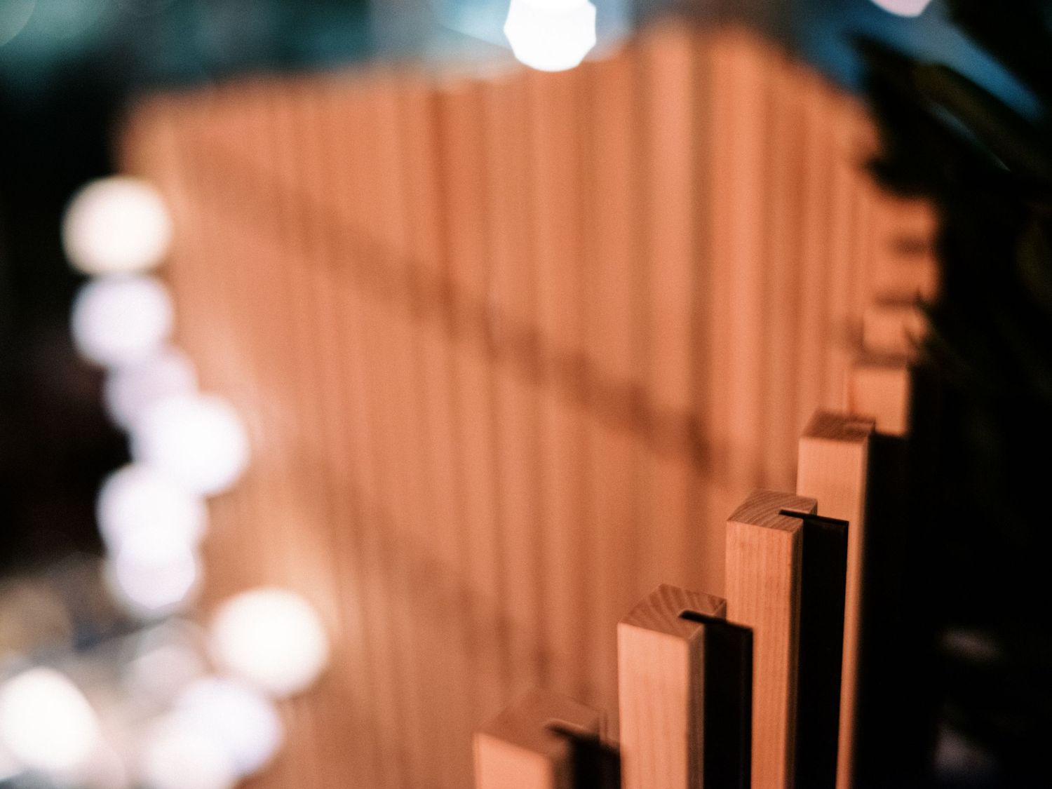 Close-up of geometric wooden wall paneling with artistic lighting effects.