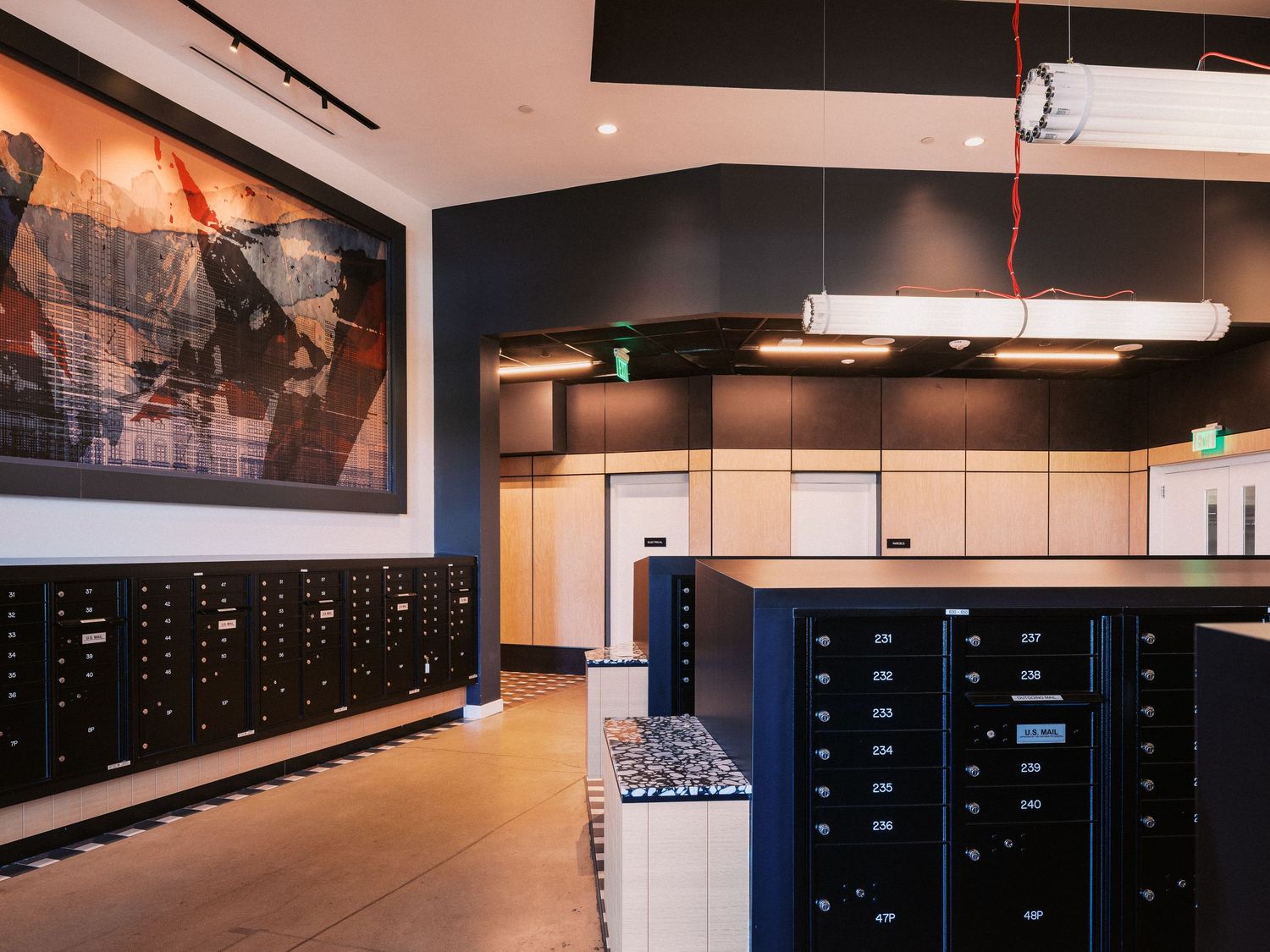 Modern office space with sleek black storage lockers and pendant lighting.