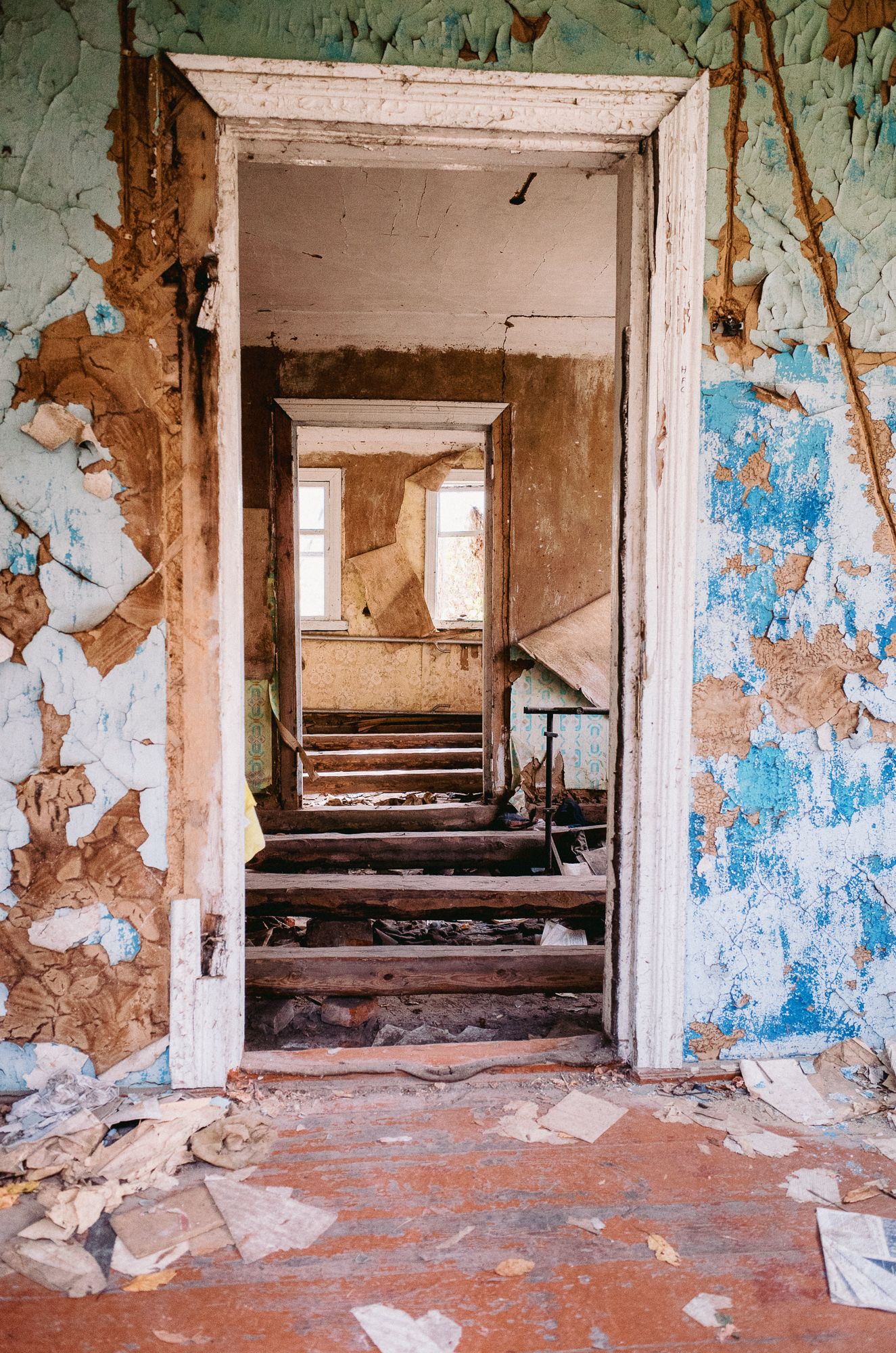 Abandoned building interior with peeling paint and debris showing urban decay.