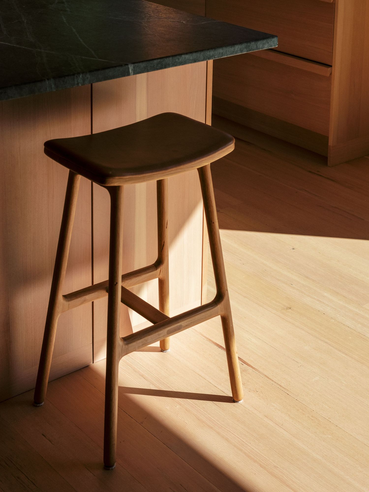 Modern wooden bar stool design photographed in sequence showing different angles in natural light.