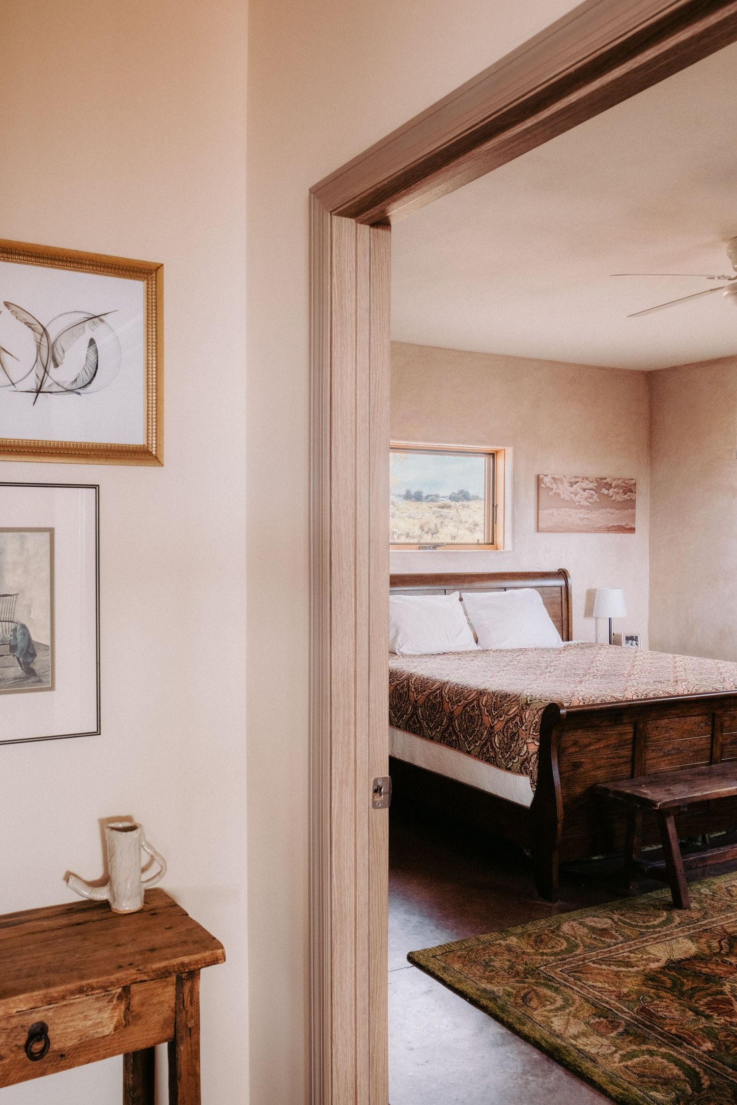 Bedroom interior with rustic wooden furniture and natural light streaming through windows.