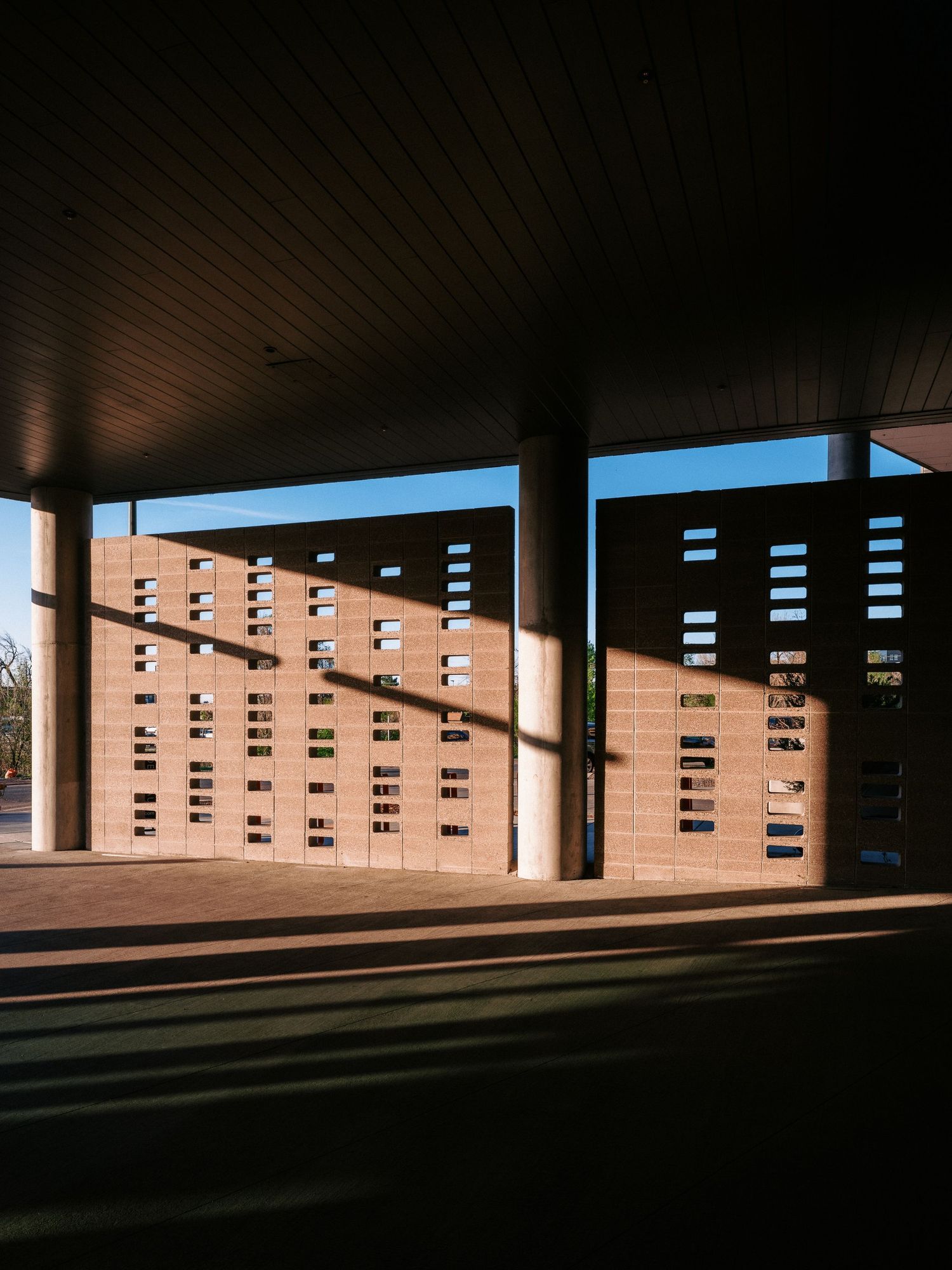 Underground parking garage with dramatic shadows and striped lighting patterns.