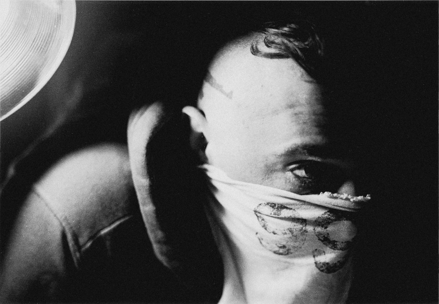 A grainy black and white artistic portrait showing dramatic shadows and light.