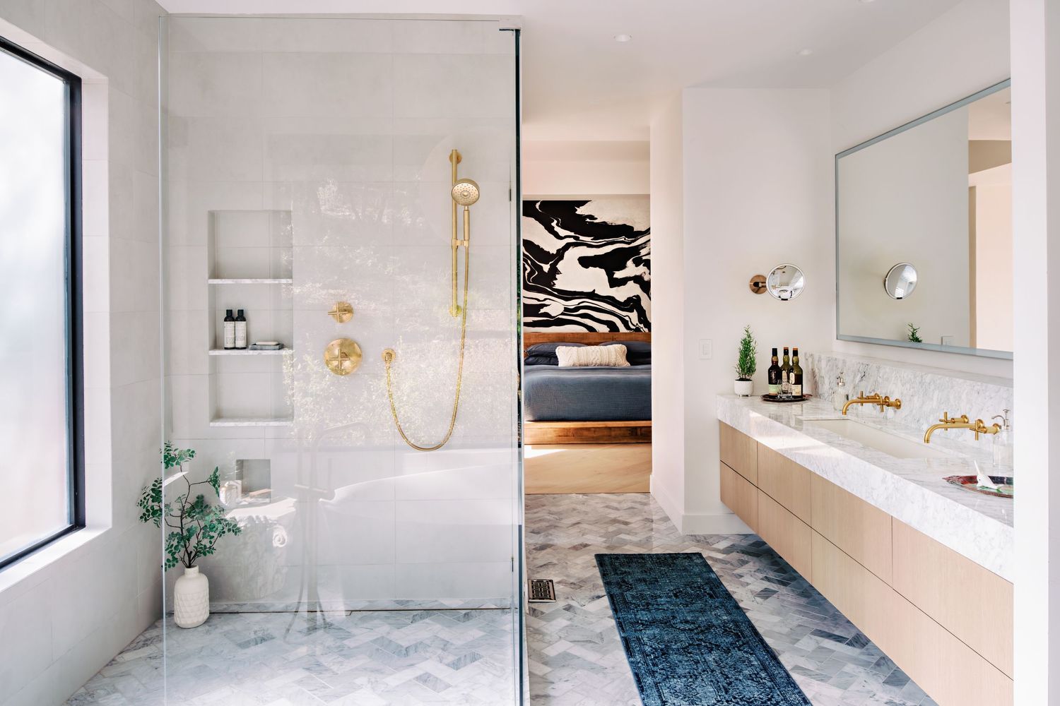 Sleek modern bathroom interior with white walls and blue accents features a freestanding tub and glass shower.