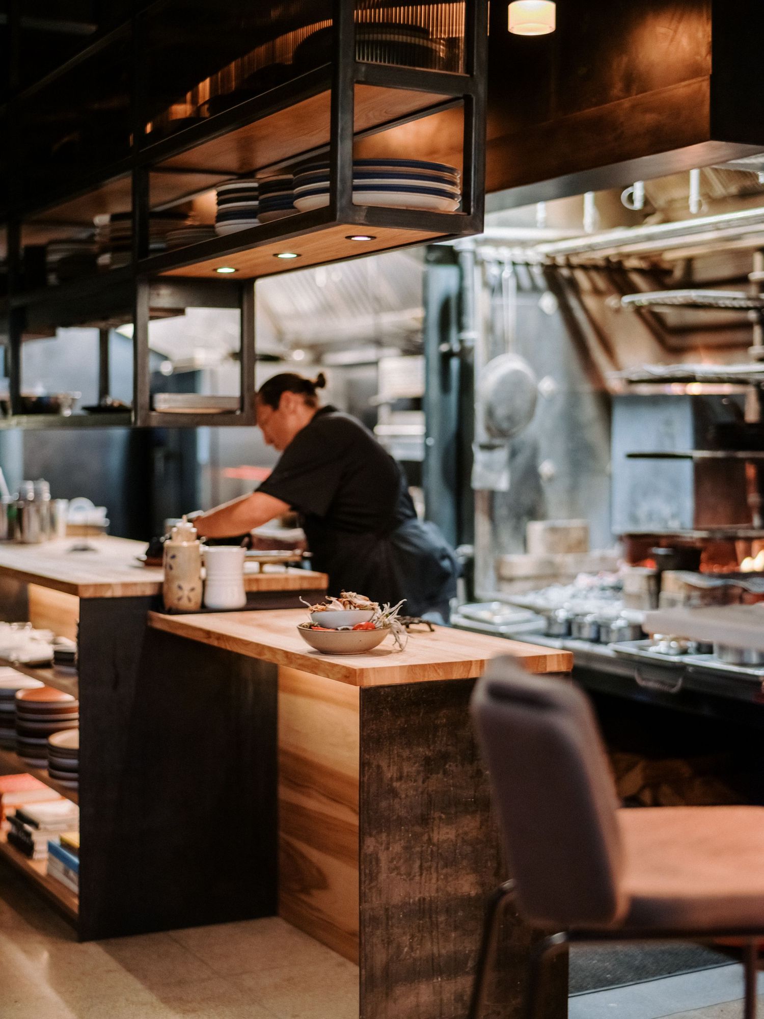 Modern restaurant kitchen counter with wooden finishes and professional equipment.
