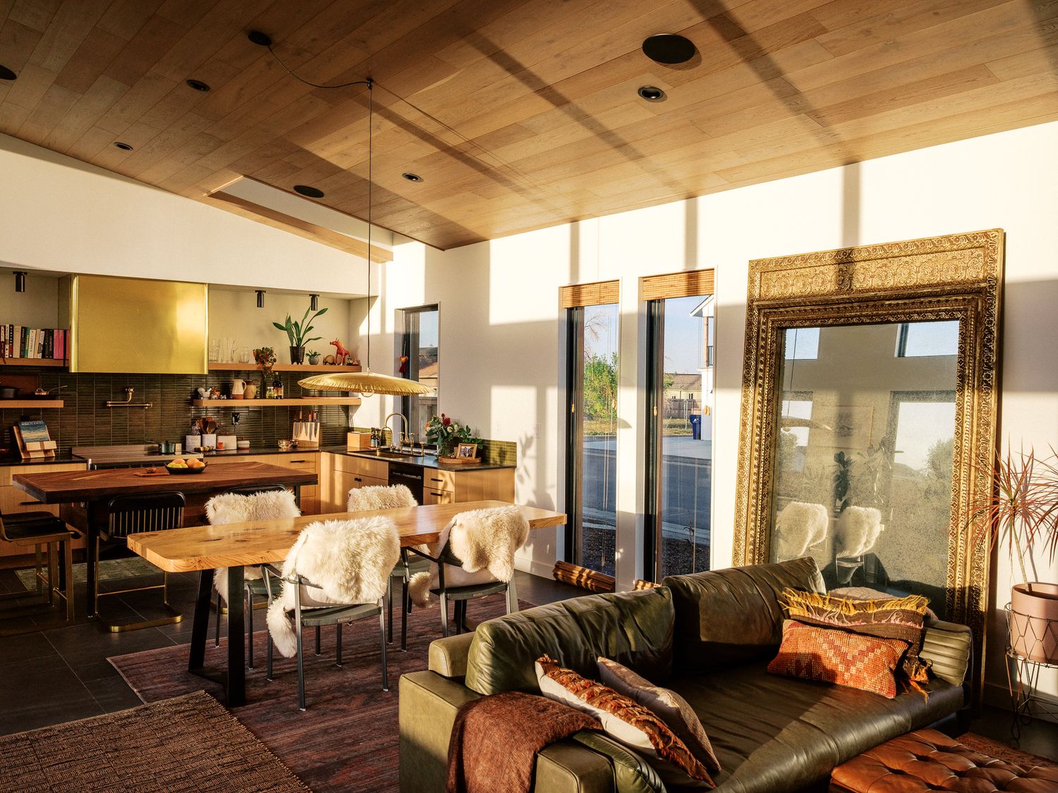 Modern living room interior with wooden ceiling and large windows providing natural light.