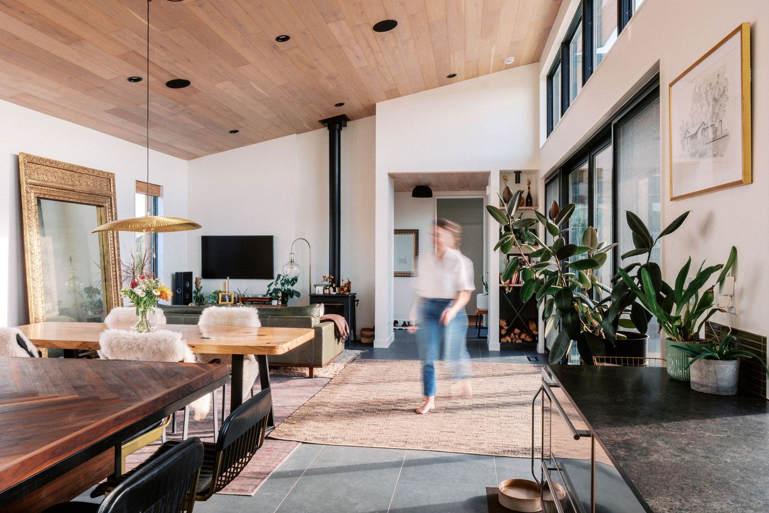 Long hallway view of modern home interior with wood ceiling and natural lighting.
