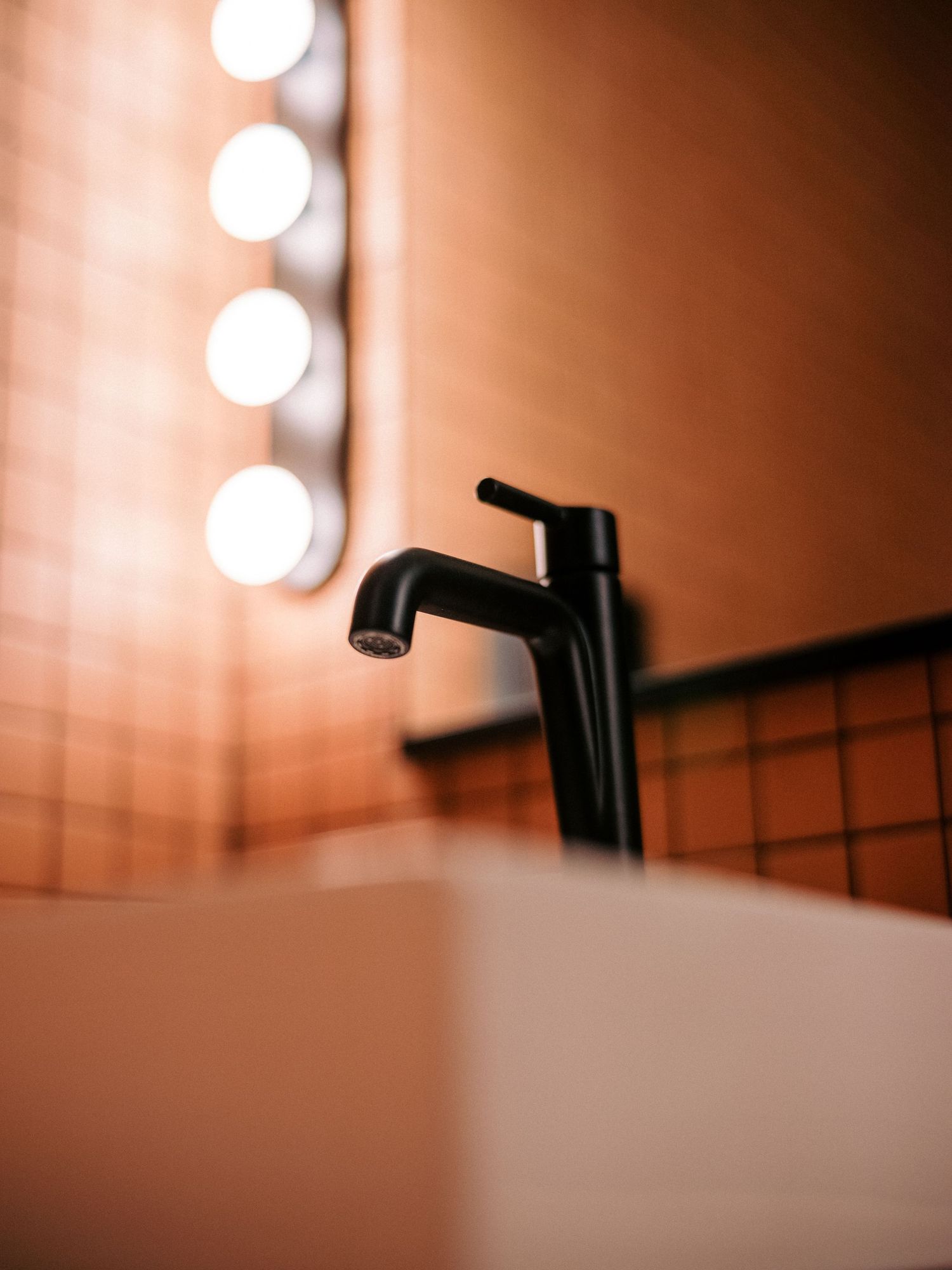 Minimalist lighting fixture detail with round bulbs mounted on wall creating soft ambient glow.
