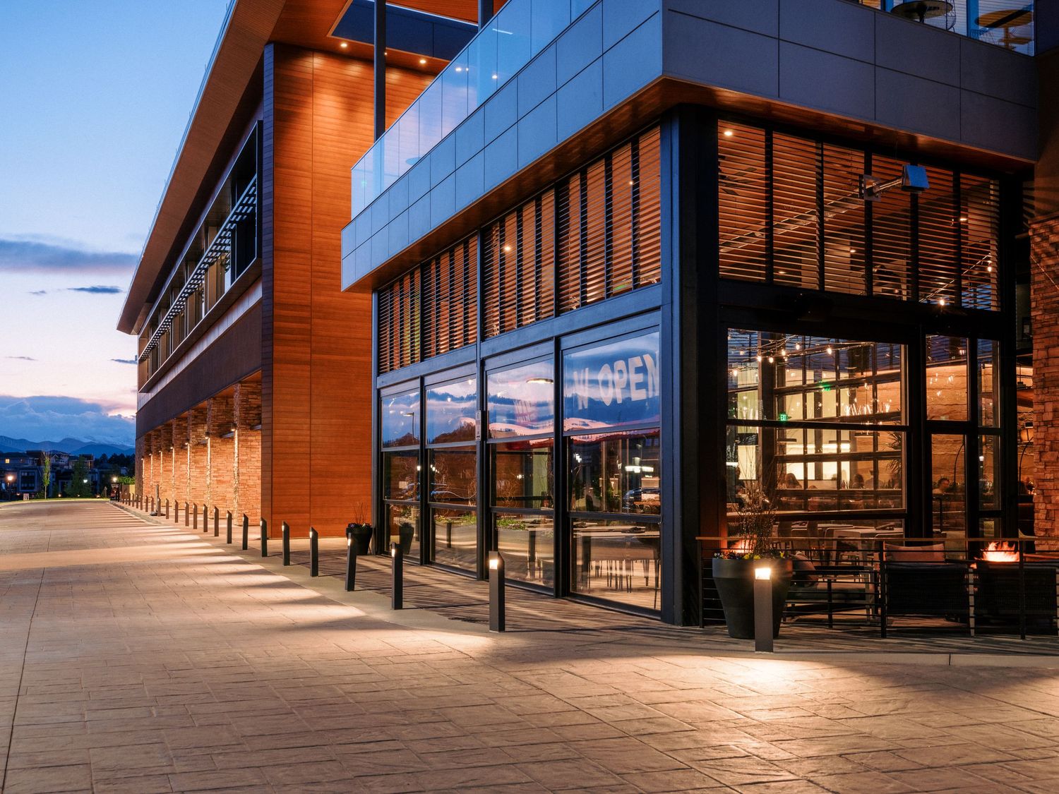 Panoramic view of modern shopping center with dramatic angular architecture and glass walls.