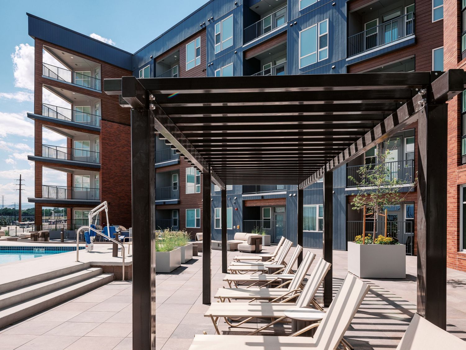 Outdoor lounge area with wooden pergola and comfortable seating.