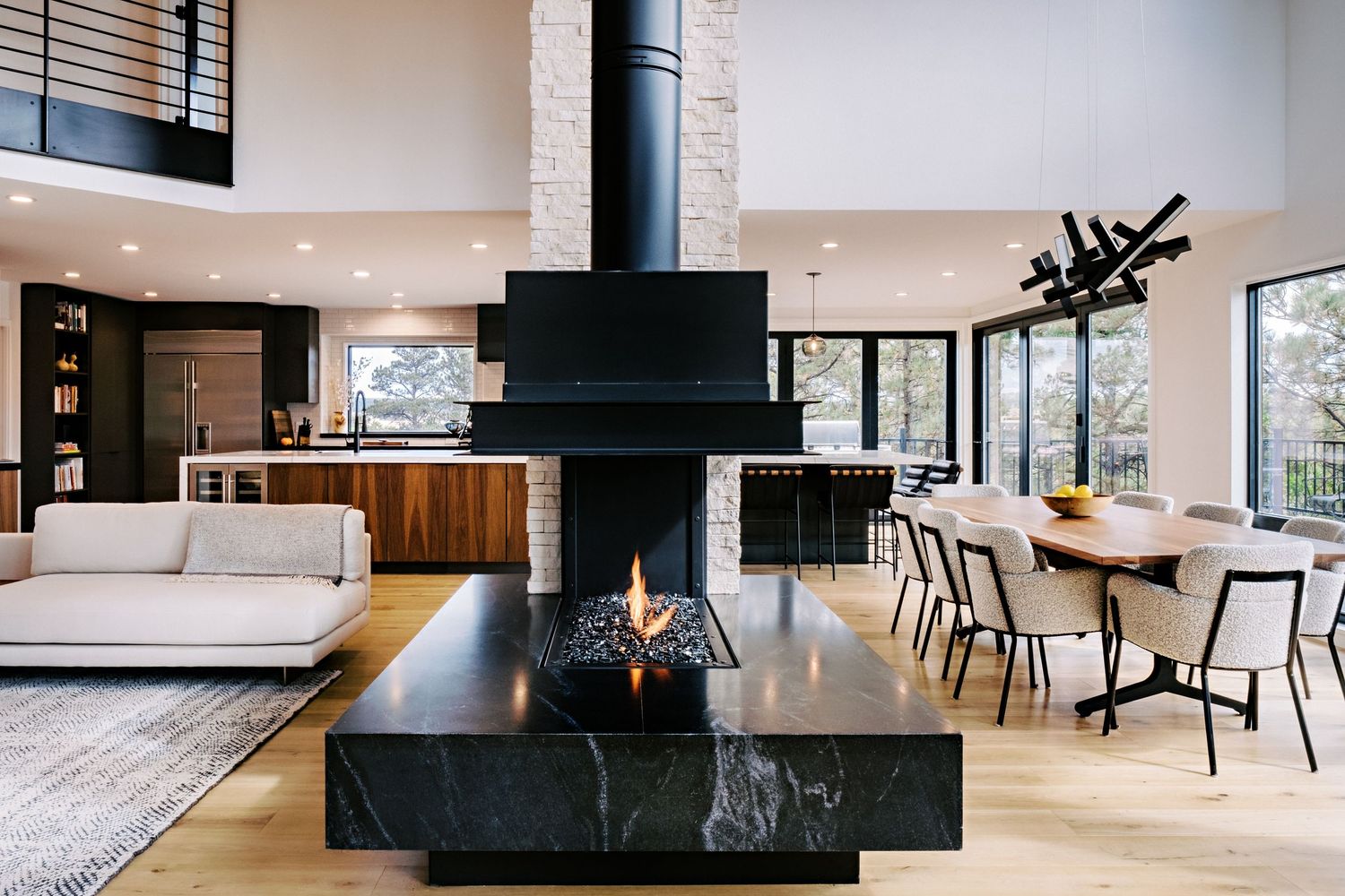 Open floor plan combines living, dining and kitchen areas with modern black and white design elements.