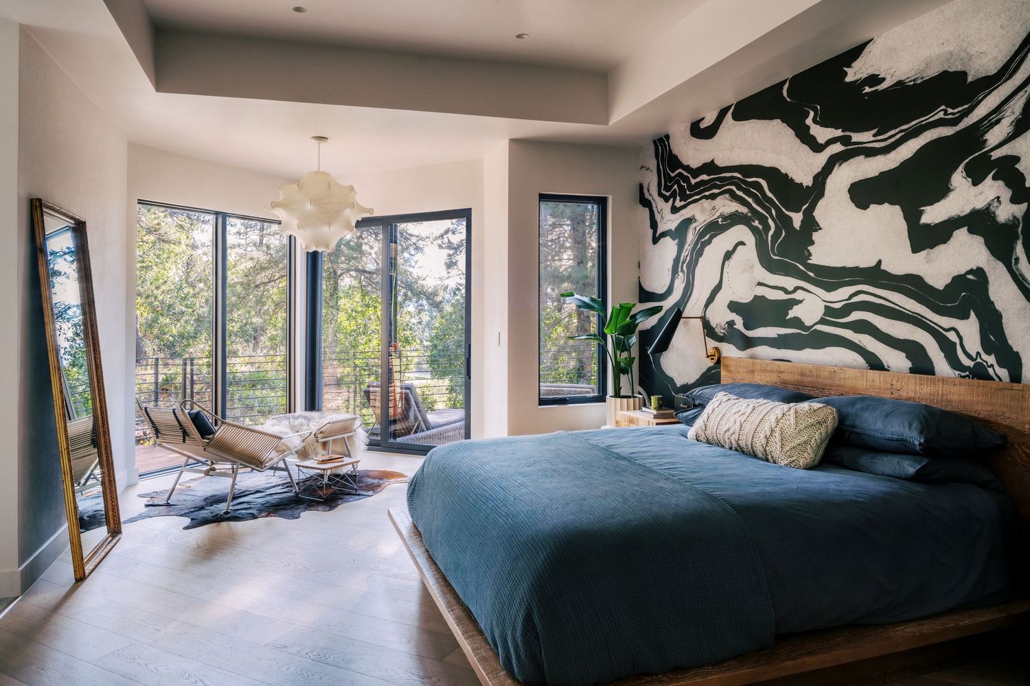 Panoramic view of a modern bedroom with large windows and abstract wall art.