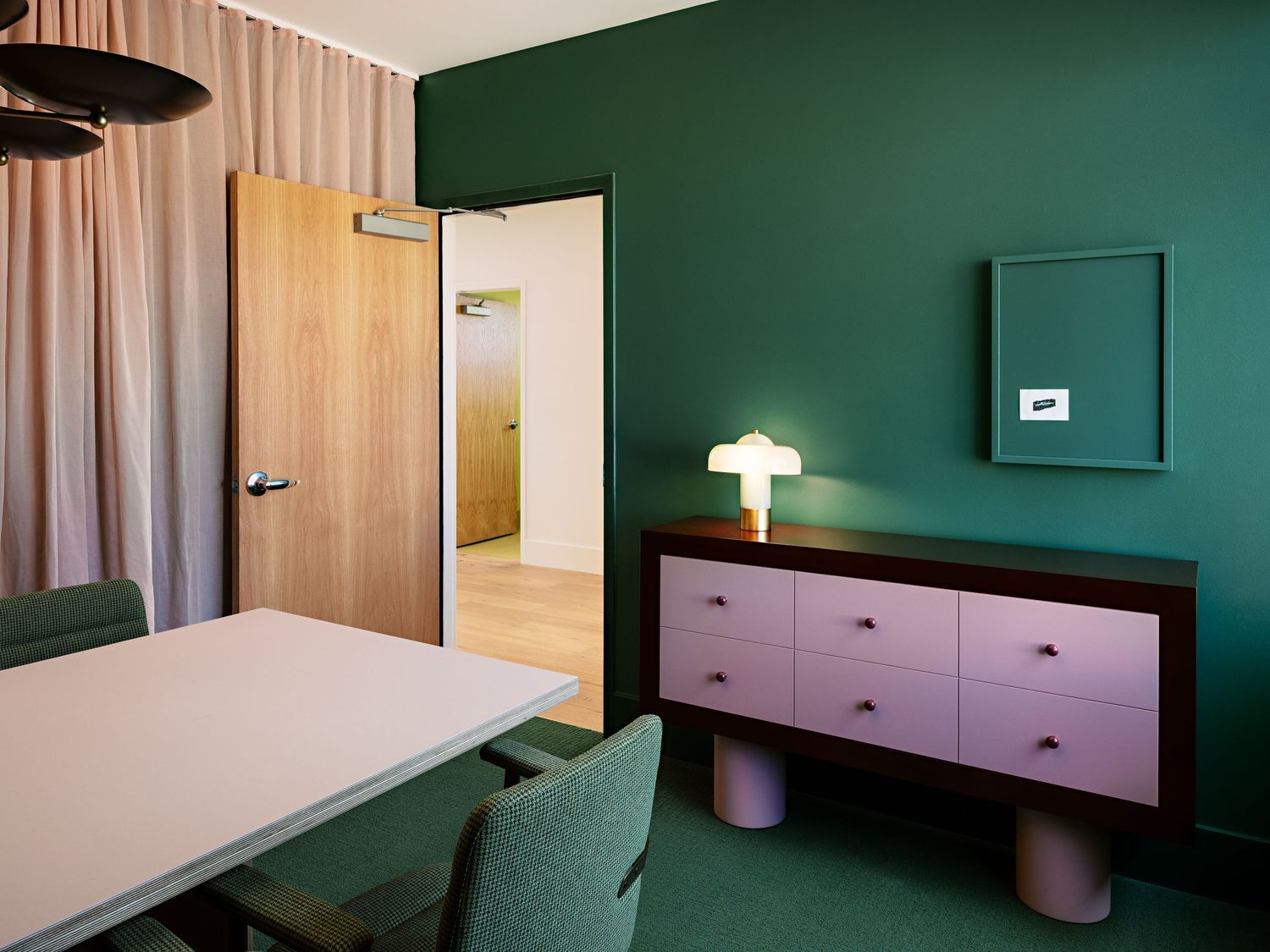 Office space with green walls and minimalist furniture and fixtures.