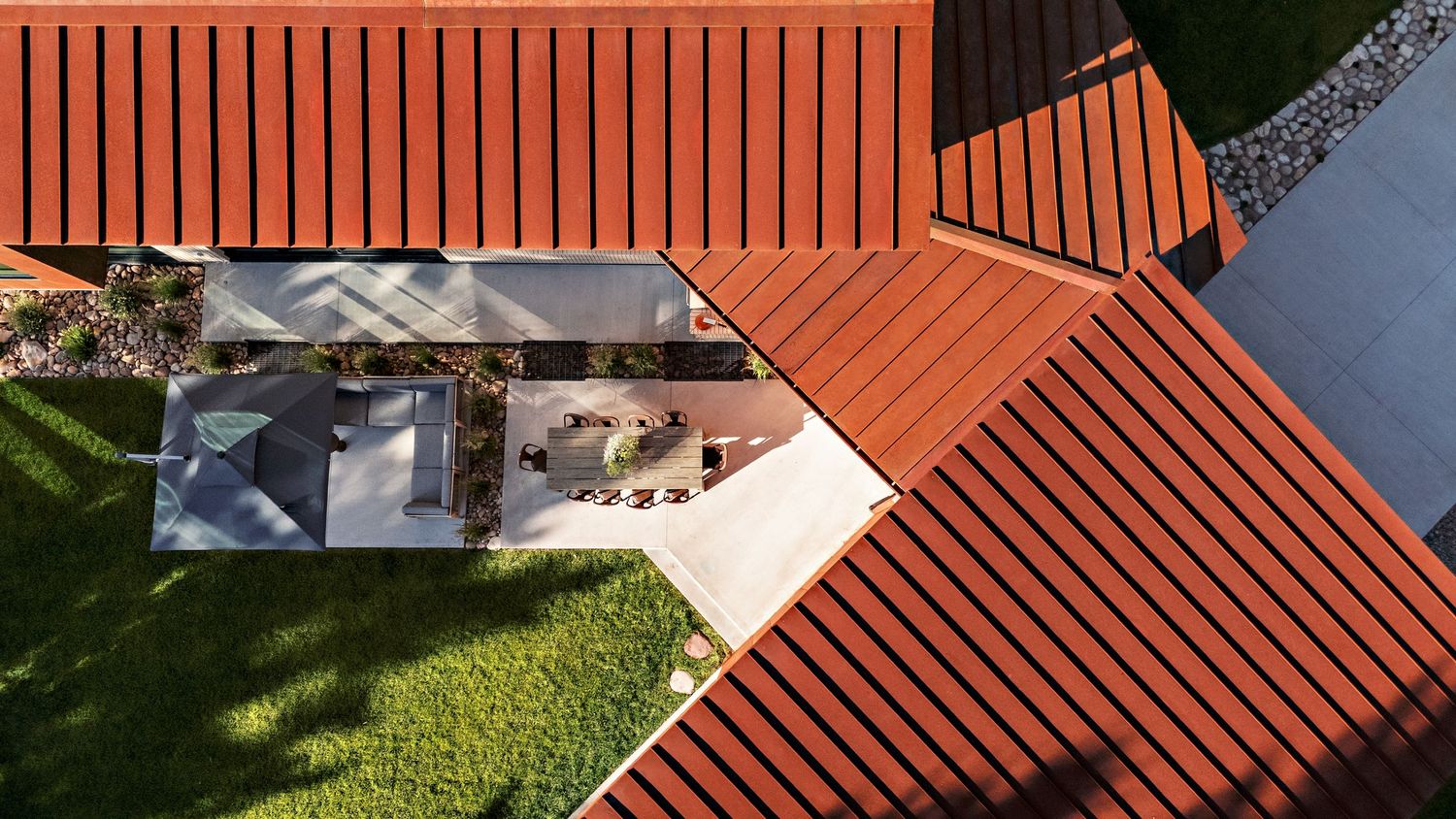Aerial view of terracotta colored roof tiles showing geometric patterns and modern architectural details.