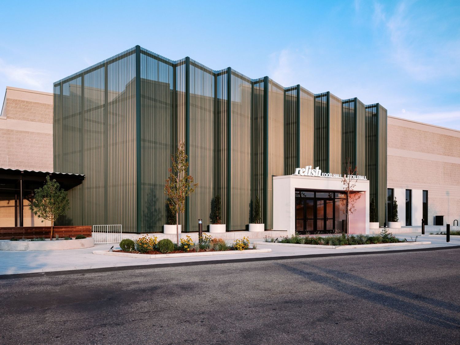 Modern industrial building exterior with glass panels and concrete facade in daylight.