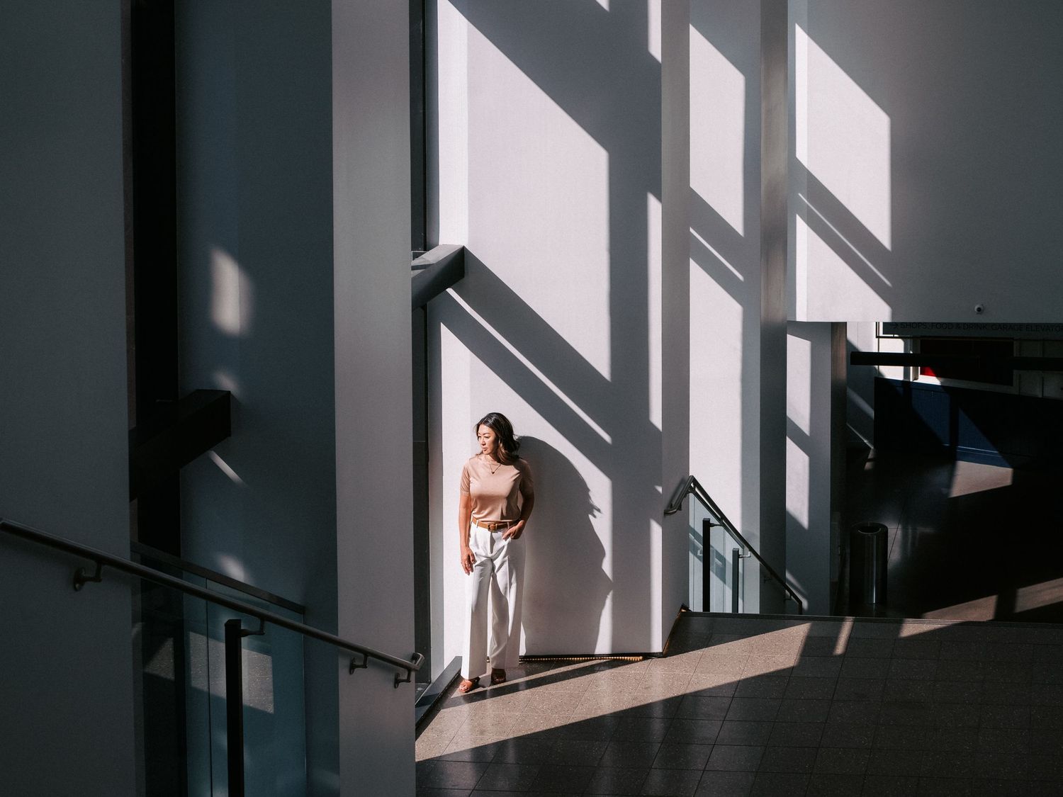 Dramatic shadows cast through windows onto a minimalist interior wall.