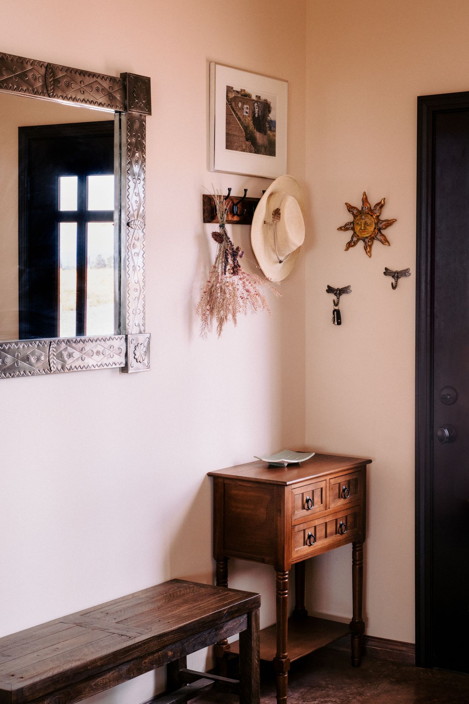 Hallway decorated with southwestern art featuring wooden furniture and ornate wall decor.