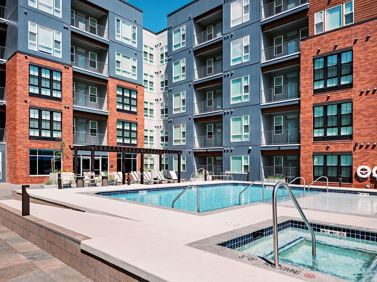 Luxury apartment complex courtyard featuring a swimming pool surrounded by modern architecture.