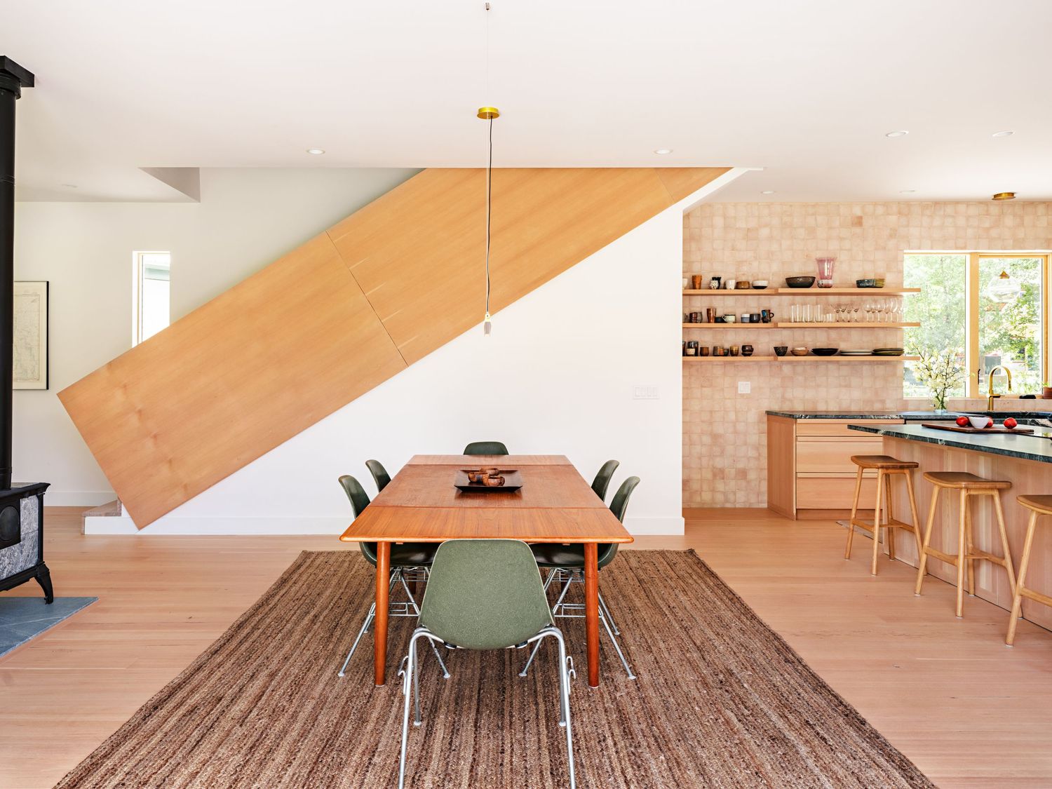 Open concept dining area with wooden floors and modern furniture showcases clean architectural lines.