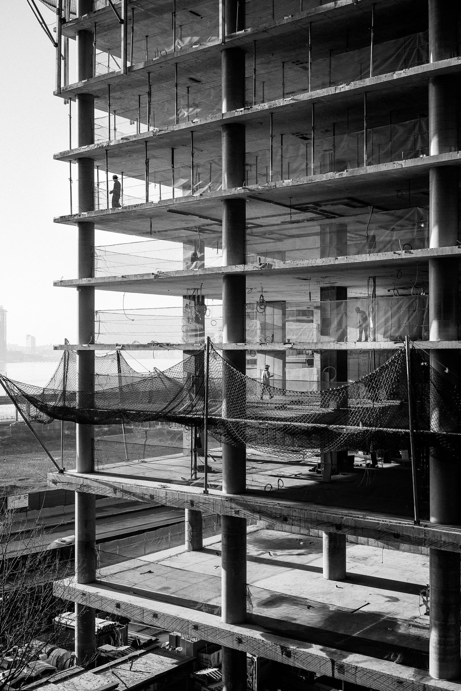 Interior construction view showing multiple concrete floors and support columns of an unfinished building structure.