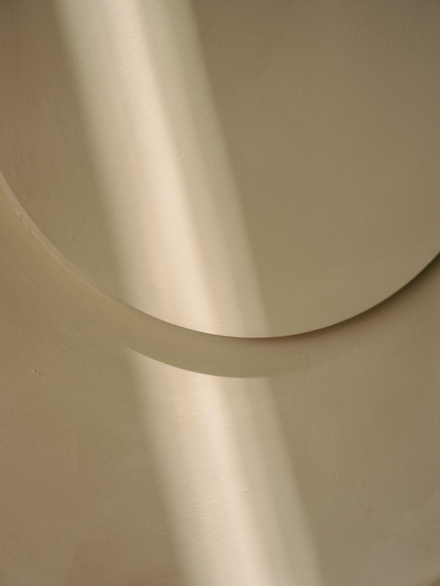 Abstract curved shapes in cream and beige tones creating a minimalist architectural detail.