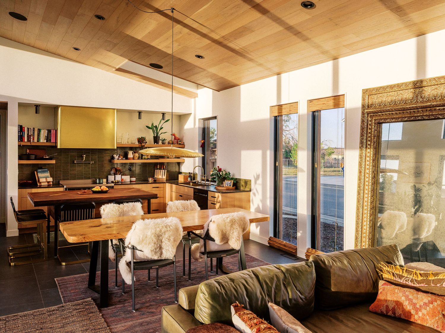 Open plan living space with wooden ceiling beams, pendant lighting, and comfortable seating areas.